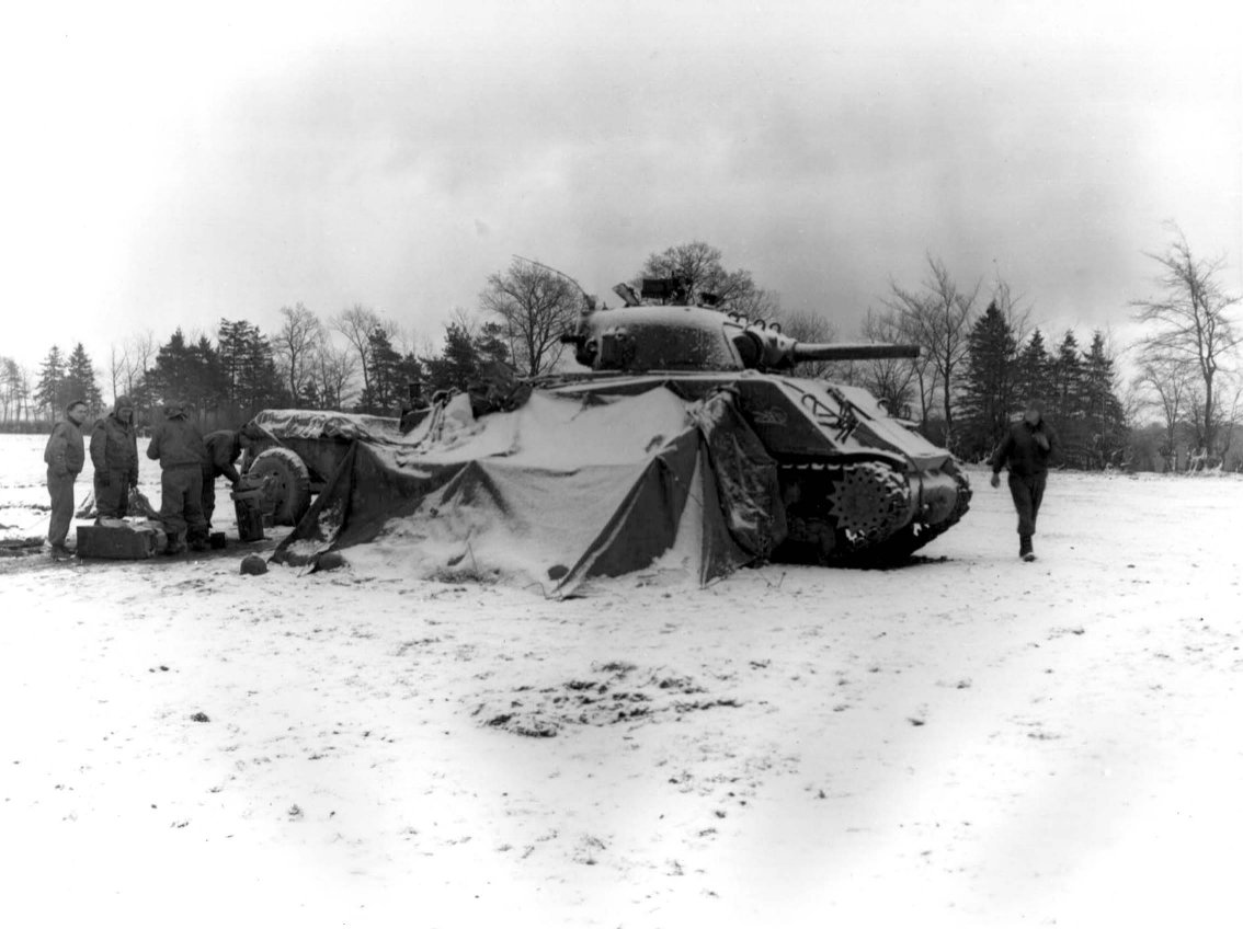 US 5th Armored Regiment tankers gathering around a fire and opening presents near Eupen, Belgium, Dec. 30, 1944 (U.S. Army Center of Military History)