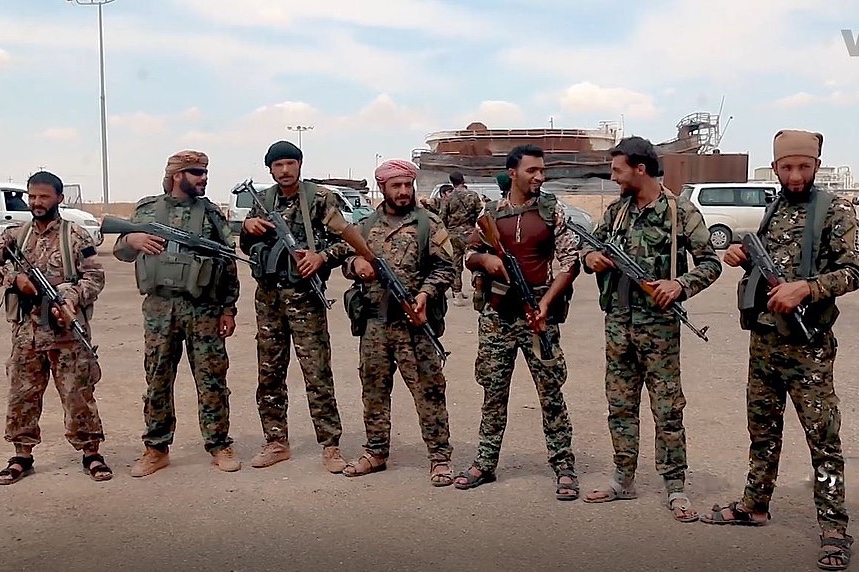 A Syrian Democratic Forces unit stands with weapons in liberated Raqqa