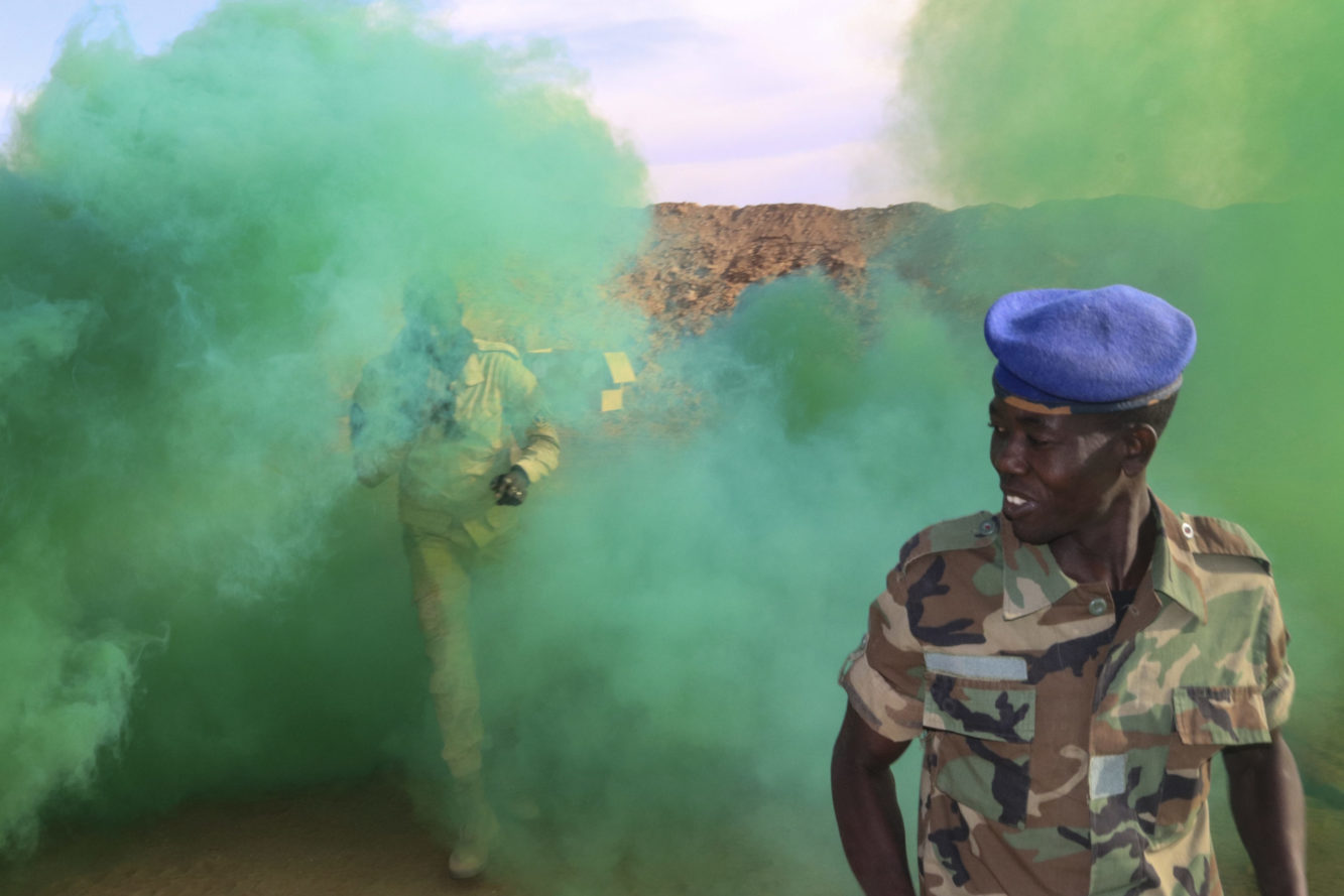 Forces Armèes Nigeriennes soldiers walk through smoke from an M18 smoke grenade