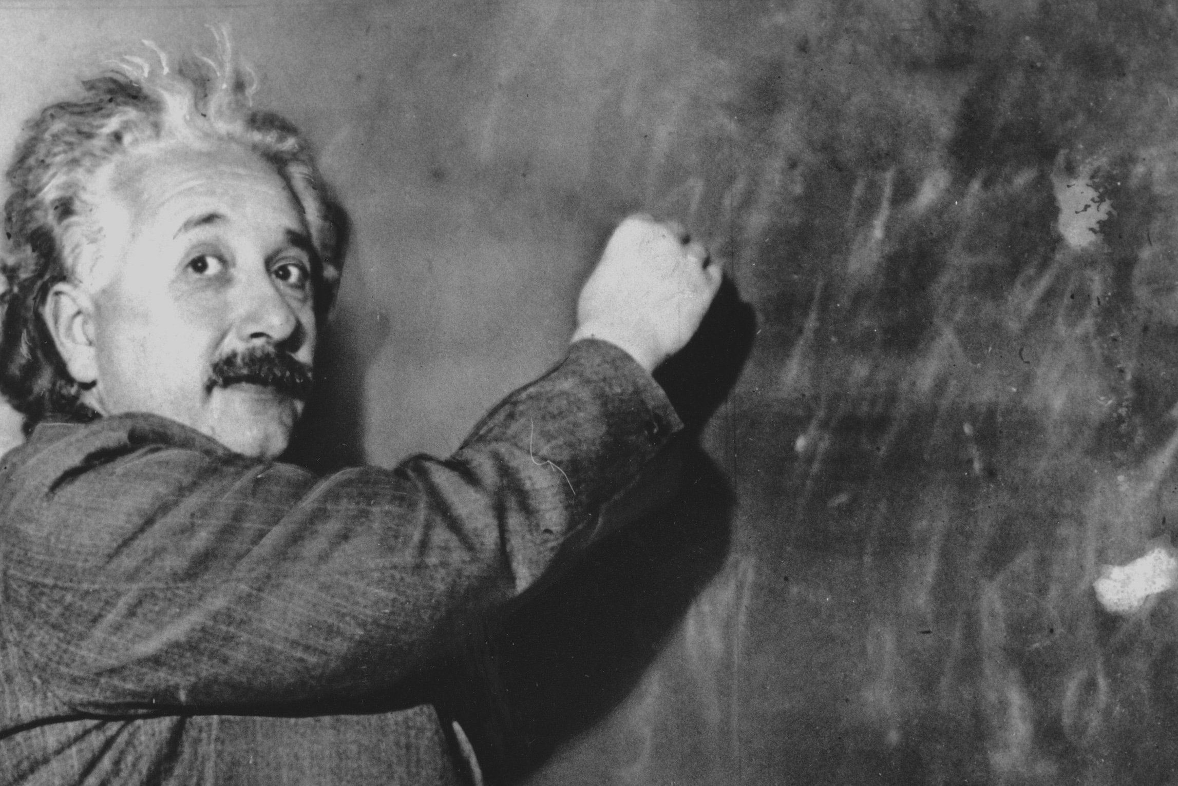 Albert Einstein writes on a blackboard