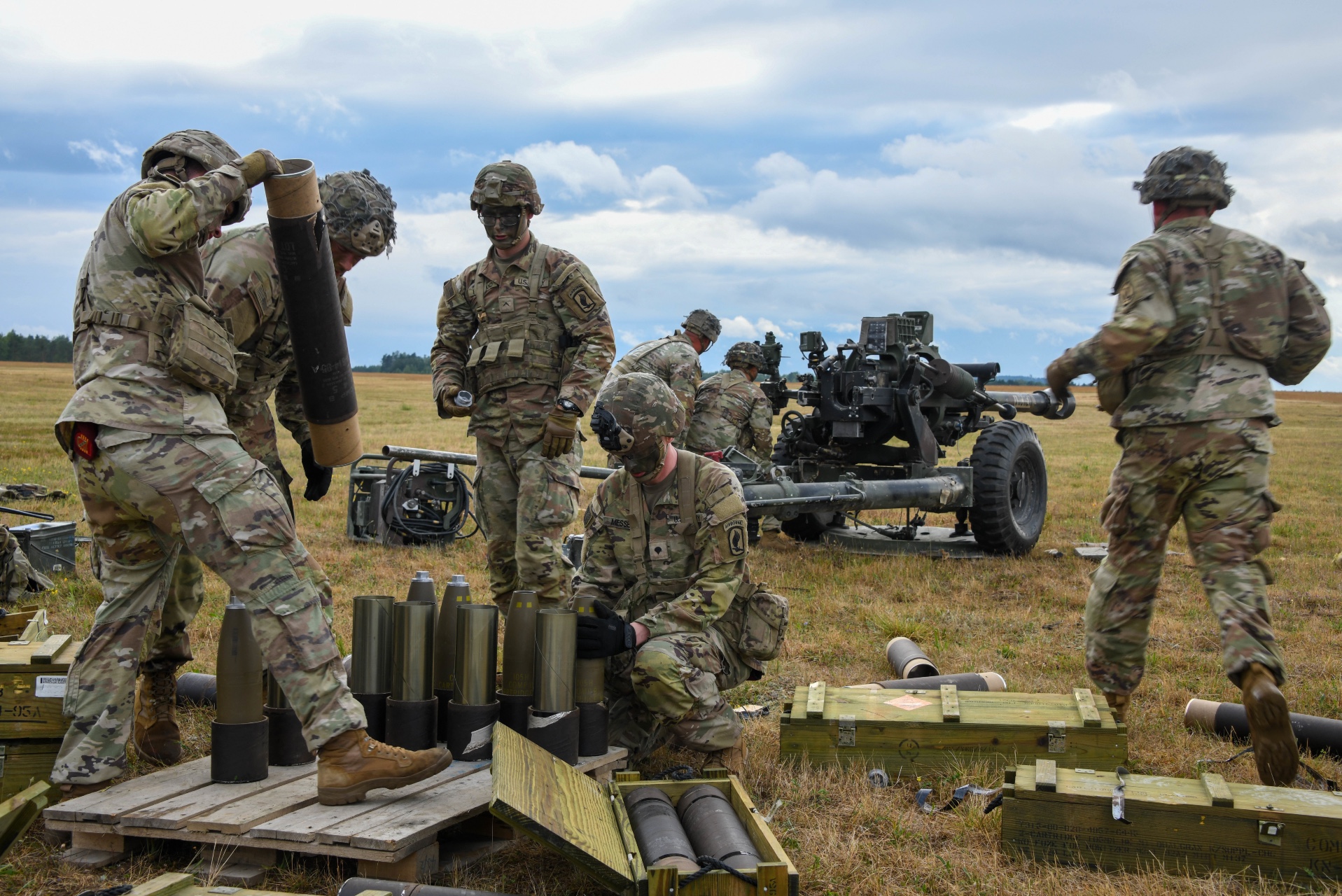 Soldiers set up 105mm munitions for a live fire training exercise