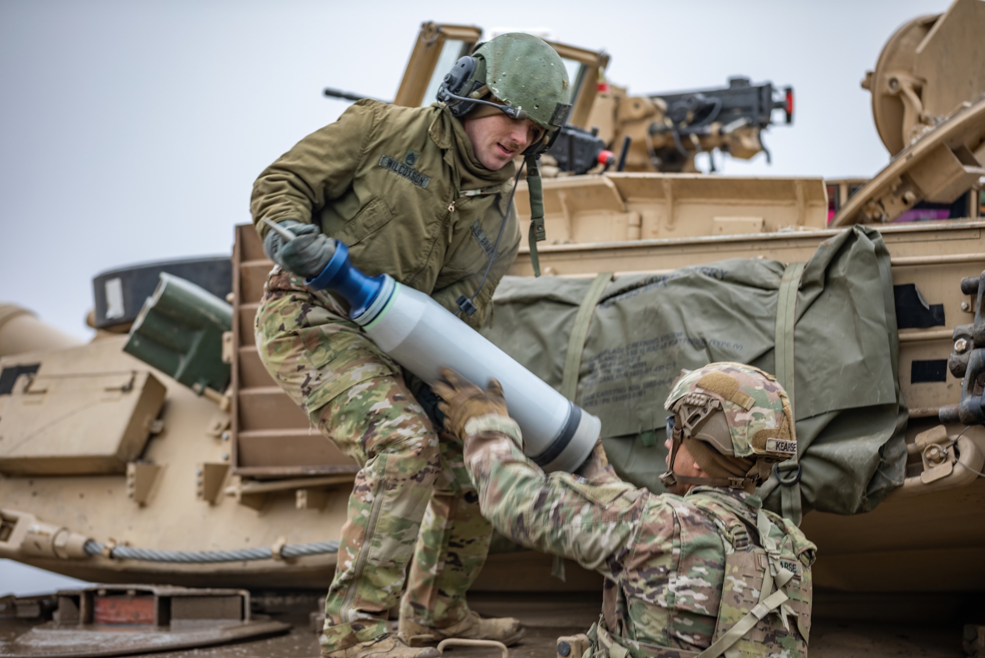 M1 armor crewmen assigned to Apache Company, 1st Battalion, 9th Cavalry Regiment, 2nd Armored Brigade Combat Team, 1st Cavalry Division, load ammunition onto a M1A2 Abrams tank during a live-fire exercise at Bemowo Piskie, Poland