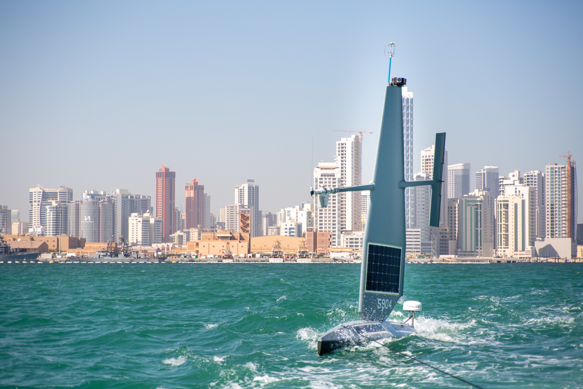 A Saildrone Explorer unmanned surface vessel (USV) is being towed out to sea in the Arabian Gulf off Bahrain’s coast