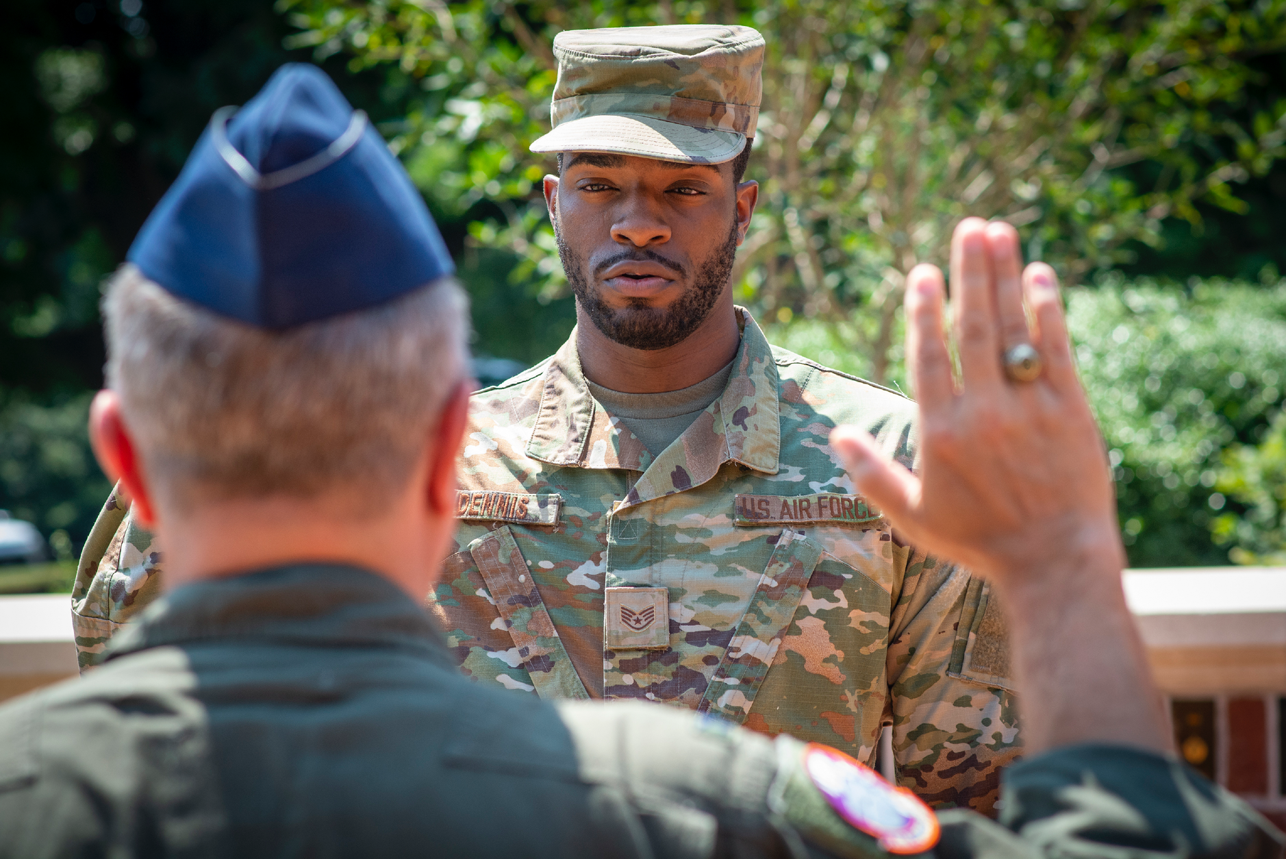 An Air Force officer takes the oath to commit to four more years of service during a reenlistment ceremony in Military Heritage Plaza