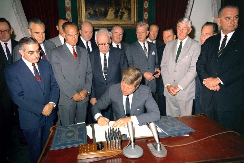 President John F. Kennedy signs the Nuclear Test Ban Treaty in the Treaty Room of the White House, Washington, D.C.