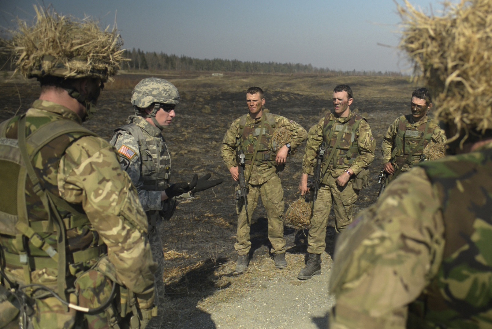 A U.S. Army second lieutenant and a current cadet at the British Army's Royal Military Academy Sandhurst, listens to feedback during an after-action review of a squad live-fire attack at the Grafenwoehr Training Area, Germany, March 13, 2014