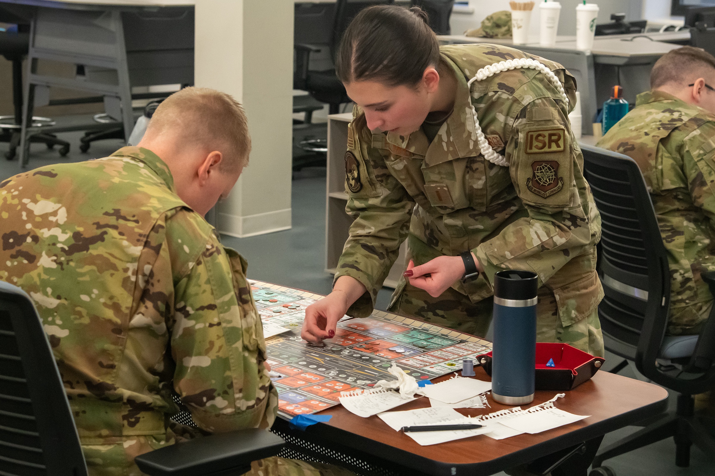 436th Operations Support Squadron deputy officer in charge of unit intelligence, uses the airfield gameboard to arrange the next move for the Kingfish ACE wargame at Dover Air Force Base, Delaware, Jan. 19, 2023.